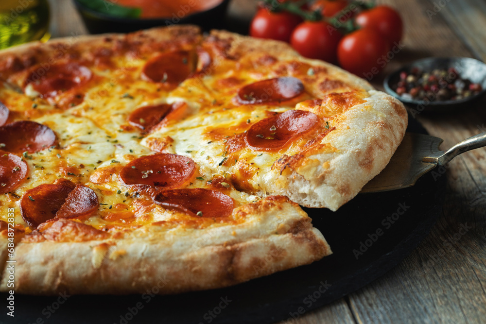 A slice of hot Italian pizza with stretching cheese. Pizza pepperoni on a dark wooden background A slice of hot Italian pizza with stretching cheese. Pizza pepperoni on a dark wooden background