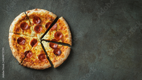 A slice of hot Italian pizza with stretching cheese. Pizza pepperoni on a dark background