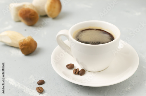 Mushroom coffee in a white cup and saucer with dried mushrooms and coffee beans. The concept of a trendy beverage. The drink is good for health. Horizontal orientation. Selective focus