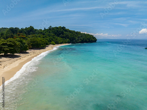 Tropical beach with white sand, turquoise water and waves. Samal, Davao. Philippines.