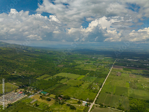 Tropical landscape: Agricultural land with plantings against a background of mountains and blue sky. Mindanao, Philippines. photo