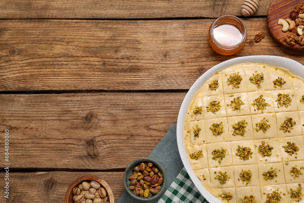 Making delicious baklava. Raw dough with ingredients on wooden table, flat lay and space for text Making delicious baklava. Raw dough with ingredients on wooden table, flat lay and space for text