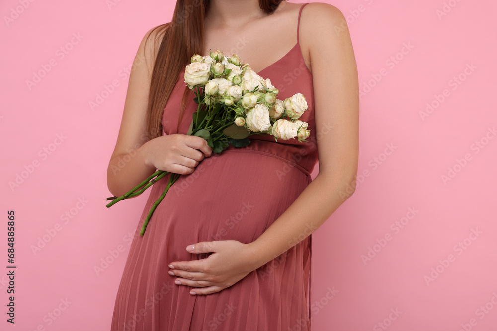 Pregnant woman in dress with bouquet of roses on pink background, closeup Pregnant woman in dress with bouquet of roses on pink background, closeup