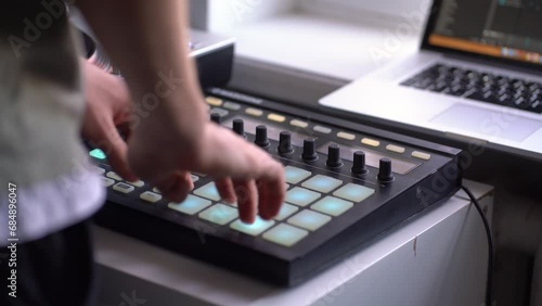 man in the home music studio, creating new song, making sound production with drum machine