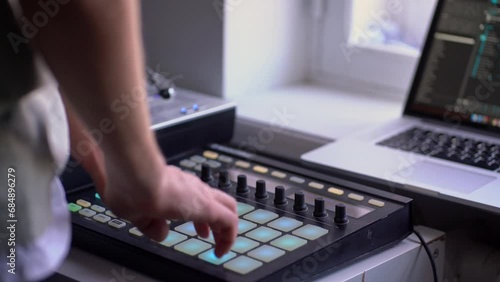 man in the home music studio, creating new song, making sound production with drum machine