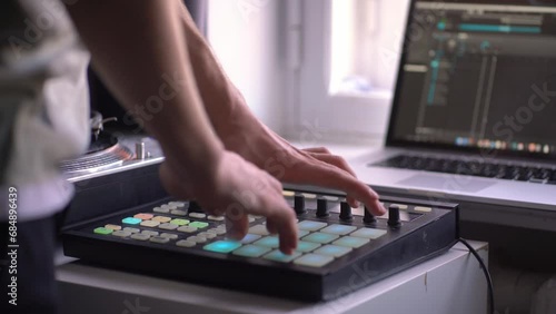 man in the home music studio, creating new song, making sound production with drum machine