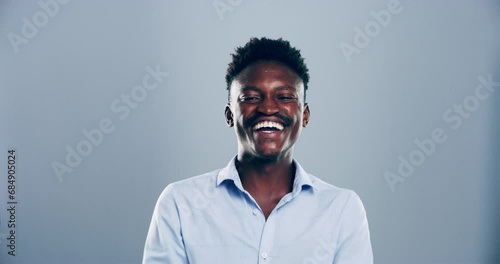 Face, man and laugh in studio with happy expression, silly joke and humor on grey background. Portrait, african model and cheerful for comedy, crazy news or funny reaction to meme, emoji or good mood photo