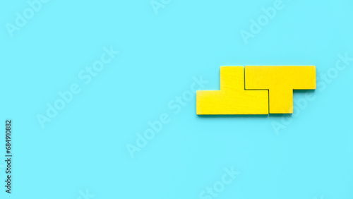 Top view two piece of yellow puzzle isolated on a blue background with copy space.