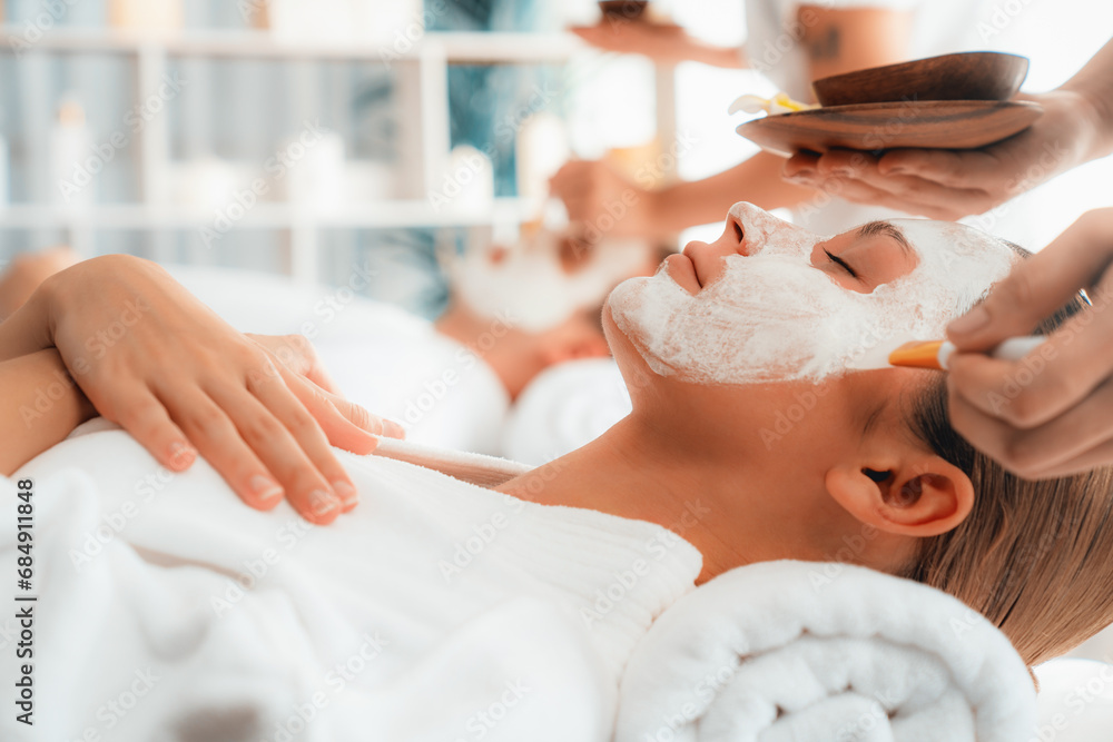 Serene ambiance of spa salon, couple indulges in rejuvenating with luxurious face cream massage with modern daylight. Facial skin treatment and beauty care concept. Quiescent - obrazy, fototapety, plakaty 