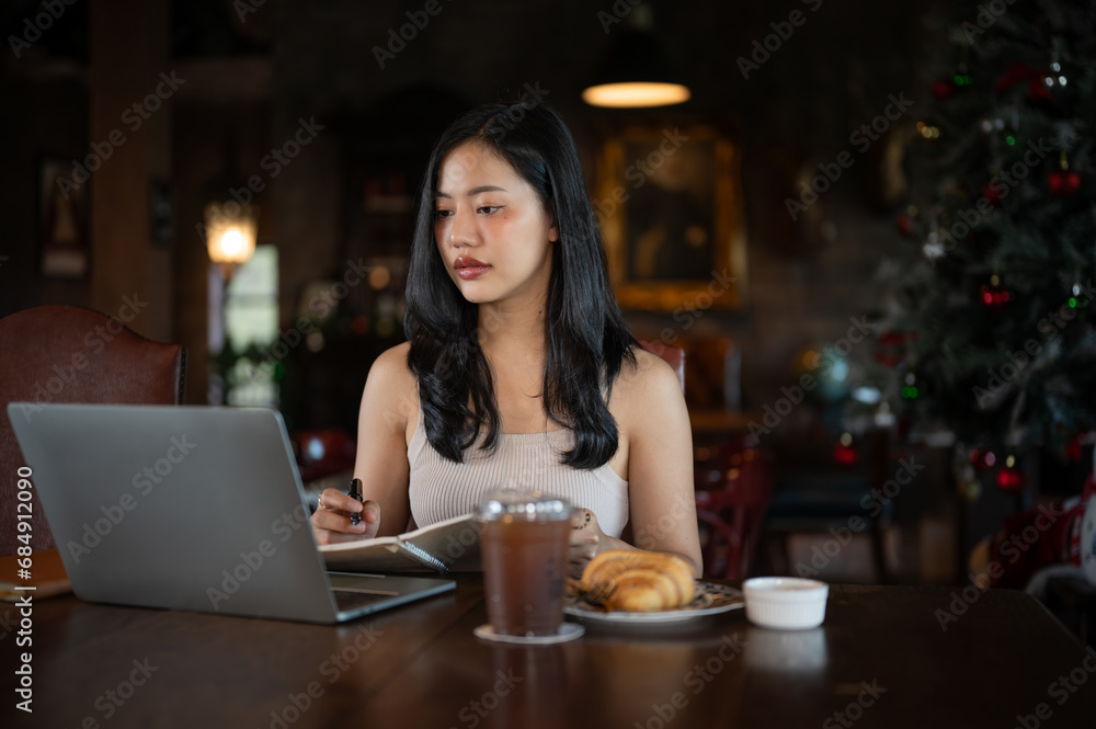 Young beautiful Asian woman working with laptop computer in a dark luxury living room. Young beautiful Asian woman working with laptop computer in a dark luxury living room.