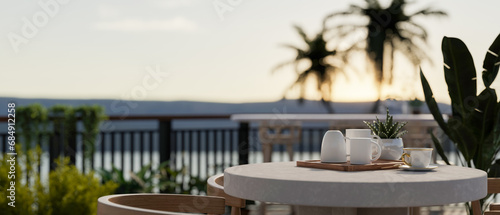 A table with a coffee mug tray on a beautiful balcony with garden and beautiful nature view.