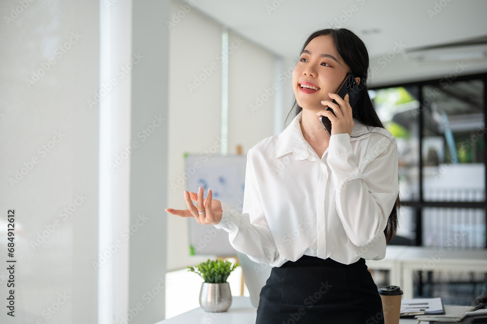 Businesswoman having a phone call with her customer while working in the office room. Businesswoman having a phone call with her customer while working in the office room.