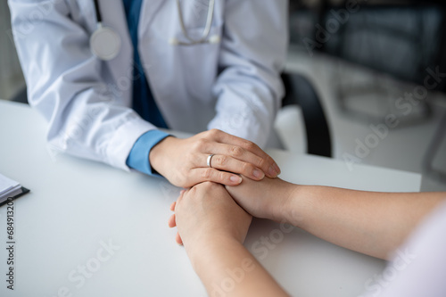 A doctor holding a patient s hands to comfort and reassure them during a medical checkup.