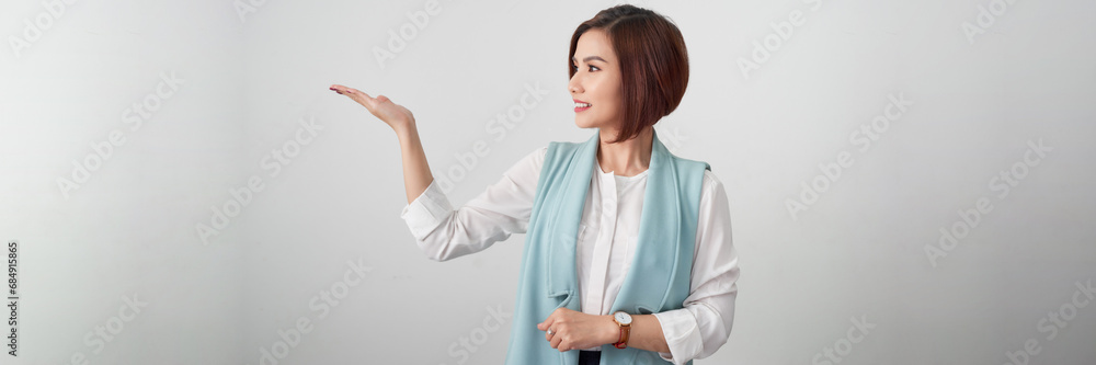 Professional beautiful Asian businesswoman shows hand to present something on white banner Professional beautiful Asian businesswoman shows hand to present something on white banner