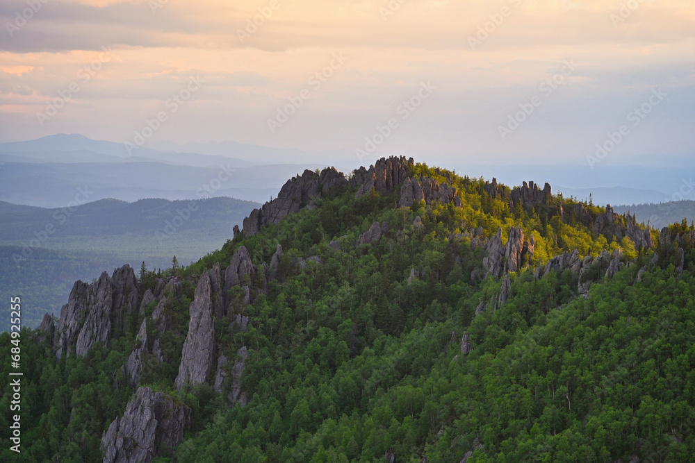 Naklejka premium Evening clouds over the mountain rocks of Taganay