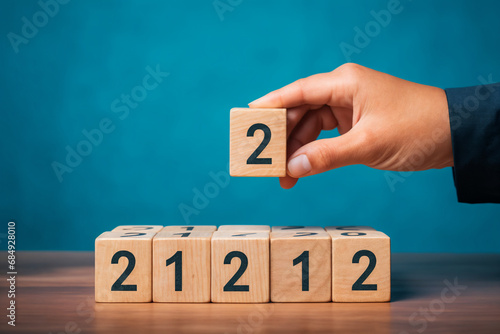 Wooden cubes with numbers and hand getting cube with number 2 on it 