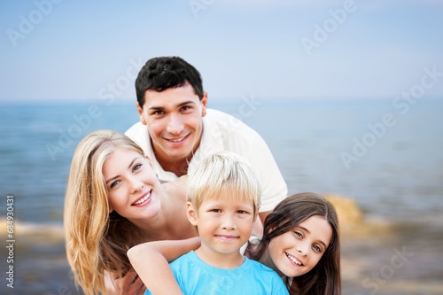 Happy family. young parents and children walk on the beach.