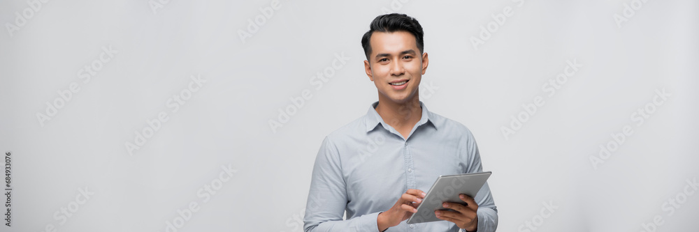 young Asian man having a smart pad PC isolated on white background. Banner young Asian man having a smart pad PC isolated on white background. Banner