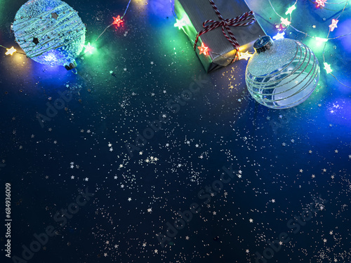 Fototapeta Naklejka Na Ścianę i Meble -  christmas gift with glass balls on blue background with colorful christmas lights.