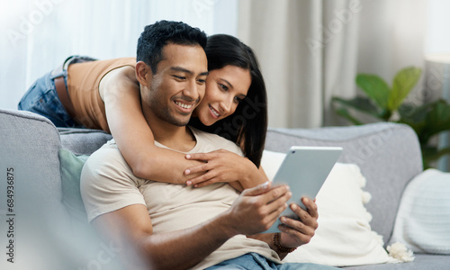 Happy, hug and couple with tablet on sofa relax with social media, movies or streaming film at home. Love, smile and people in living room with digital, search or app for show, video or communication