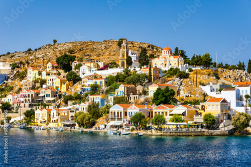 Fototapeta Naklejka Na Ścianę i Meble -  View of the beautiful greek island of Symi (Simi) with colourful houses and small boats. Greece, Symi island, view of the town of Symi (near Rhodes), Dodecanese.