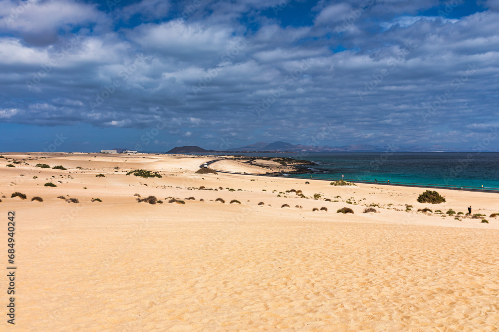 Naklejka premium Sand dunes, Las Dunas de Corralejo, Corralejo Natural Park, dramatic cloud formation, Fuerteventura, Canary Islands, Spain. Sand dunes landscape, Corralejo, Fuerteventura, Canary Islands, Spain.
