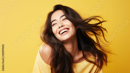 Happy young woman on a yellow background