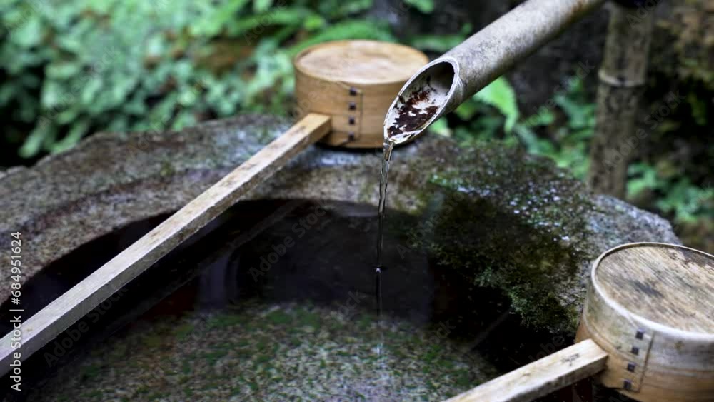 Japanese Water Fountain With Bamboo Ladles Resting On Side. Close Up, Slow Motion Shot Japanese Water Fountain With Bamboo Ladles Resting On Side. Close Up, Slow Motion Shot