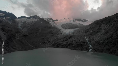 Aerial view of the Gauli glacier and lake in the Bernese Oberland region of the Swiss Alps at the end of a cloudy day. photo