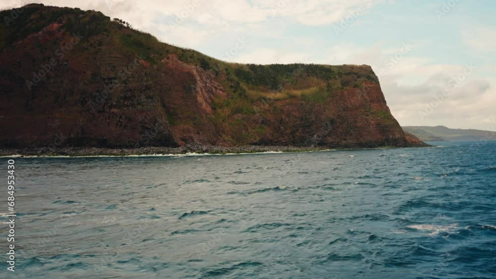 Slow motion view of high cliffs rocky coastline from the ocean. Slow motion view of high cliffs rocky coastline from the ocean.