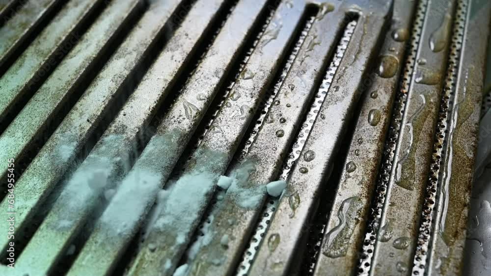 Housekeeping pouring baking soda on the surface of stained cooker hood