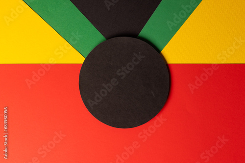 Green, yellow and red papers with black circle and copy space on black background