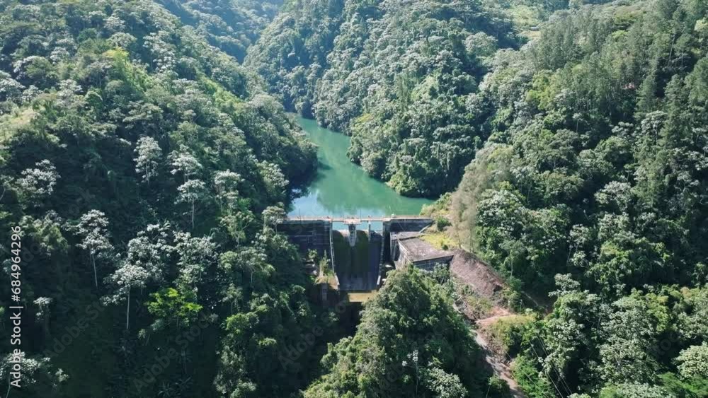 Aerial backwards shot of Tireo Dam in deep jungle during sunny day on Dominican Republic Island - Panorama view Aerial backwards shot of Tireo Dam in deep jungle during sunny day on Dominican Republic Island - Panorama view