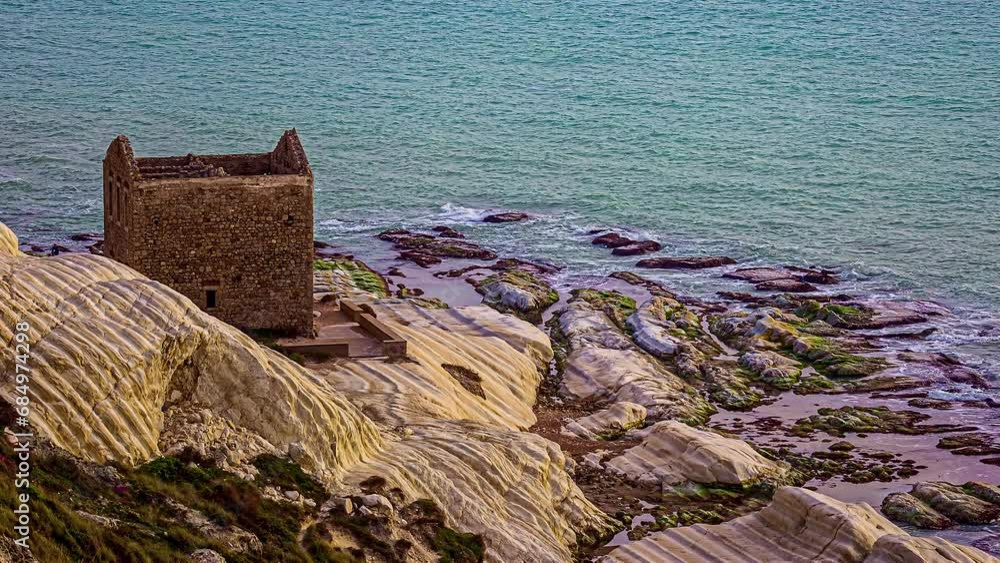 High angle shot over old ruins of an abandoned tone house along white beach on cliff, Punta Bianca, Agrigento in Sicily, Italy.
