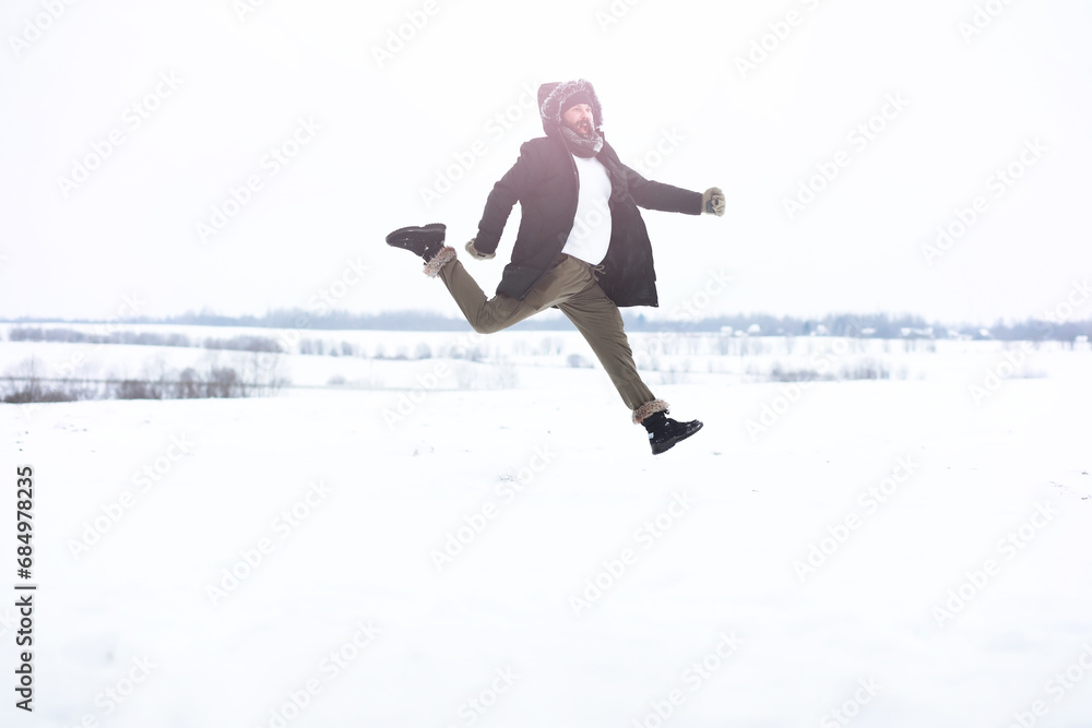 Outdoor portrait of handsome man in coat and scurf. Bearded man in the winter woods. Outdoor portrait of handsome man in coat and scurf. Bearded man in the winter woods.