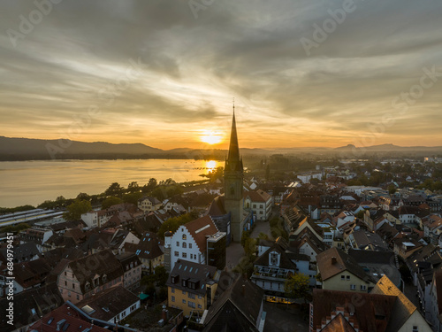 Luftbild vom historischen Stadtkern der Stadt Radolfzell am Bodensee kurz vor Sonnenuntergang. In der Bildmitte das Radolfzeller Münster und der Marktplatz, rechts am Horizont die Hegauberge