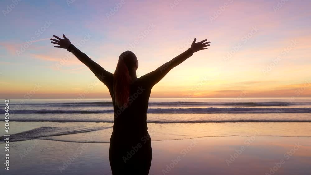 woman spreading her arms and watching the sea at dawn. woman spreading her arms and watching the sea at dawn.