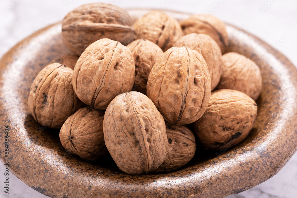 walnuts in shell on ceramic bowl walnuts in shell on ceramic bowl