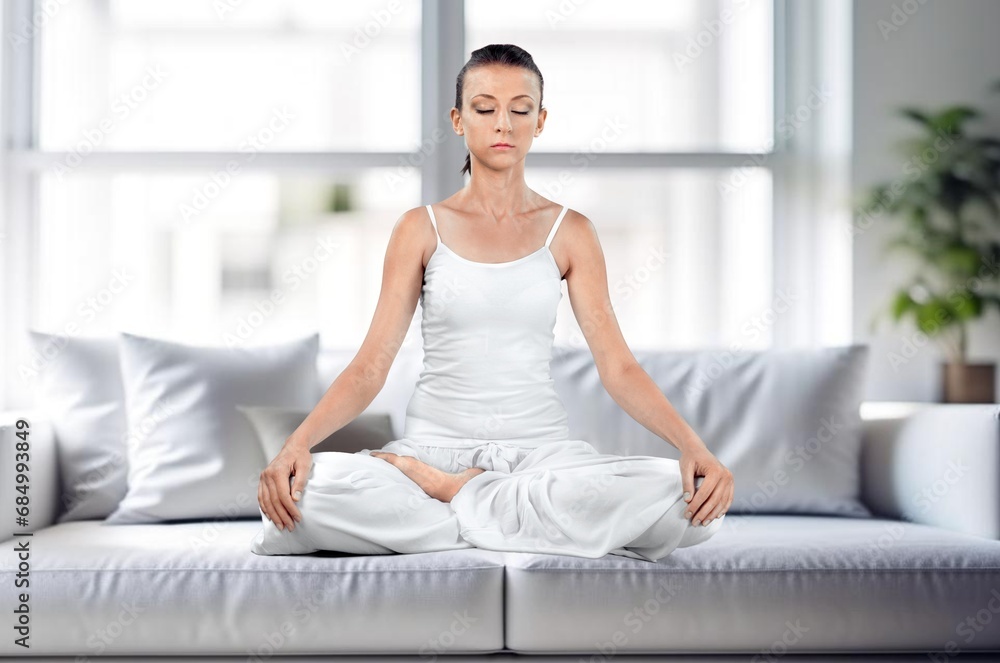 Young female meditating sitting at home Young female meditating sitting at home