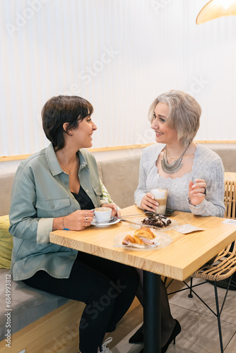 Mature women enjoying coffee while talking in cafe