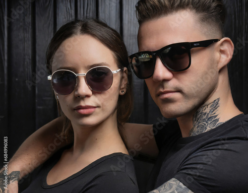 Stylish couple in sunglasses. A man and a woman in black T-shirts.