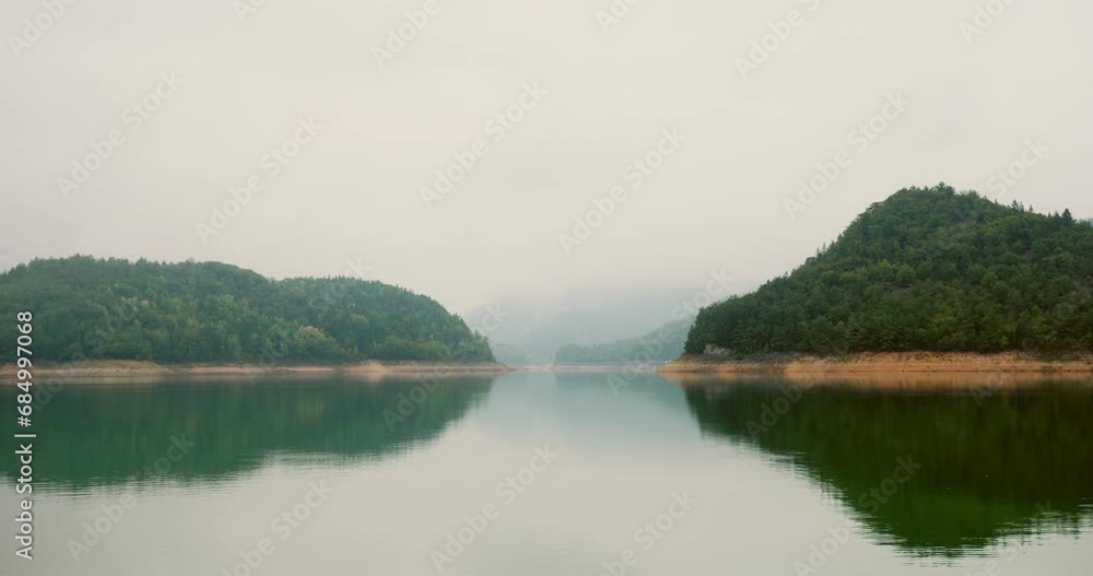 Time lapse of water flowing and reflecting nearby woodland in fog in Serbia Time lapse of water flowing and reflecting nearby woodland in fog in Serbia