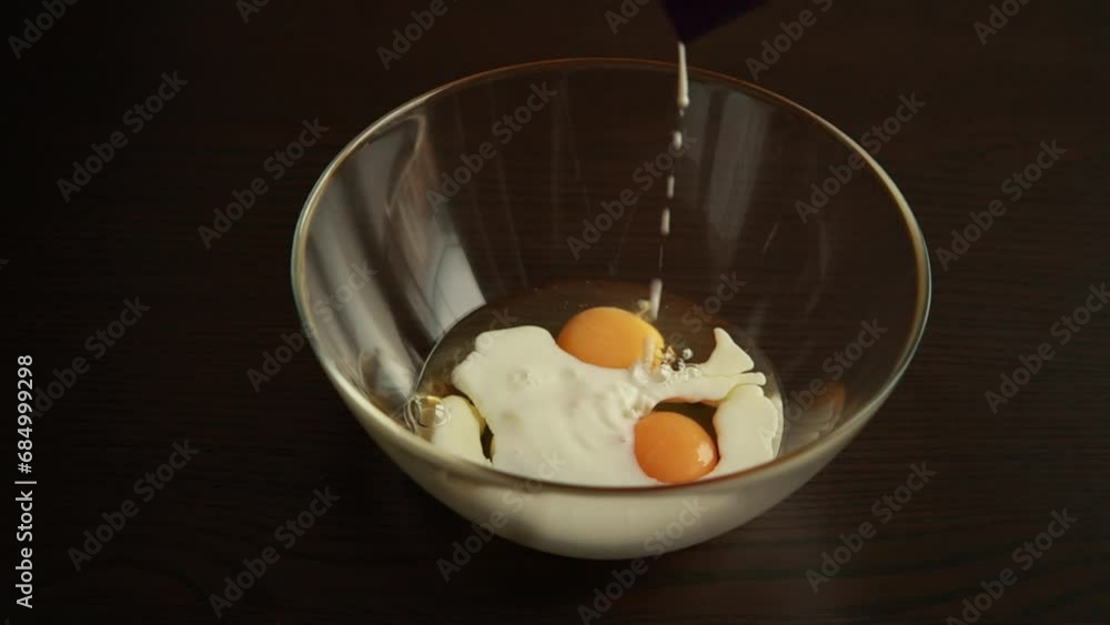 Close-up of hands pouring milk into measuring cup to make biscuits. Close-up of hands pouring milk into measuring cup to make biscuits.