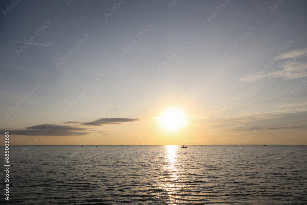 Dramatic sunrise ocean view with silhouette small boat and peaceful morning sky.Image use for travel and meteorology background. Dramatic sunrise ocean view with silhouette small boat and peaceful morning sky.Image use for travel and meteorology background.