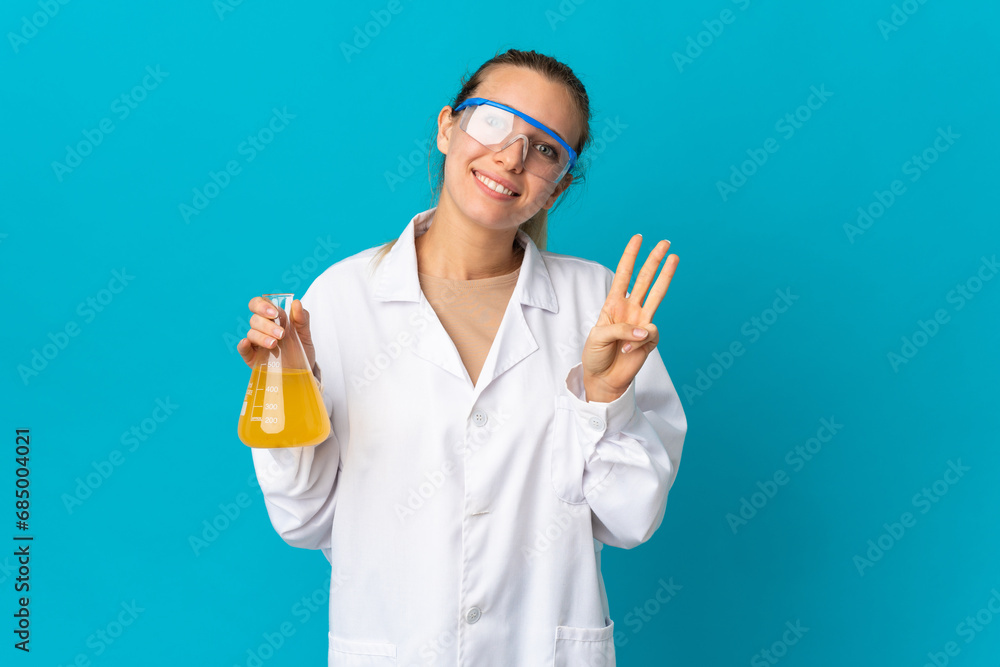 Young scientific woman isolated on blue background happy and counting three with fingers Young scientific woman isolated on blue background happy and counting three with fingers