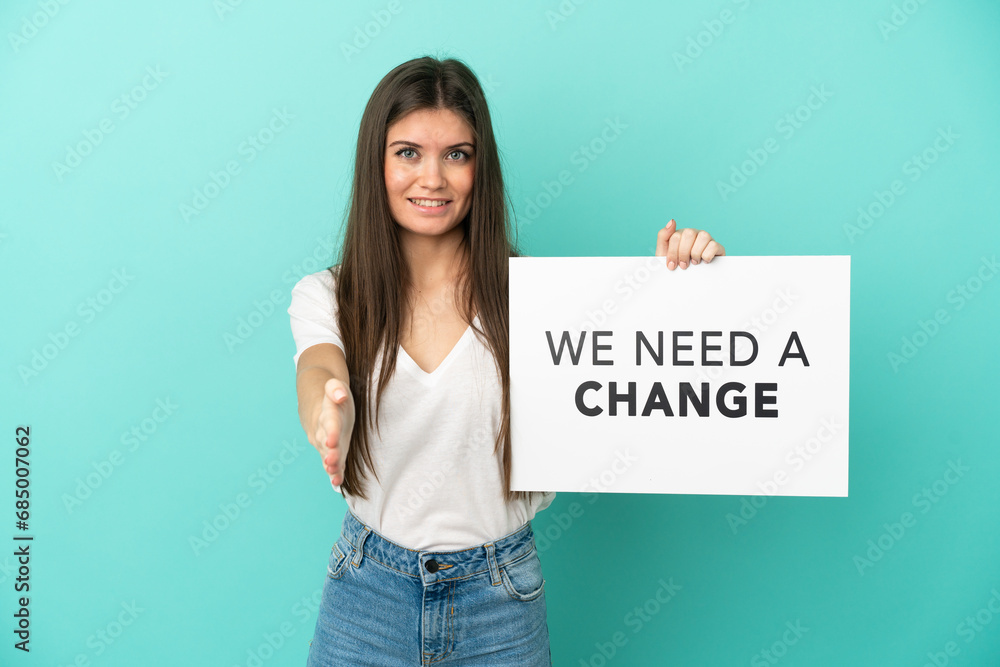 Young caucasian woman isolated on blue background holding a placard with text We Need a Change making a deal Young caucasian woman isolated on blue background holding a placard with text We Need a Change making a deal