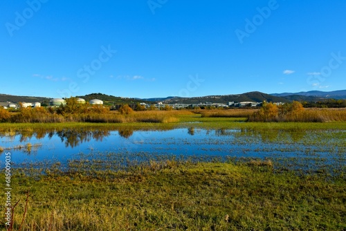 View of Skocjanski zatok wetland near Koper and industrial buildings and forest covered hills in Primorska, Slovenia