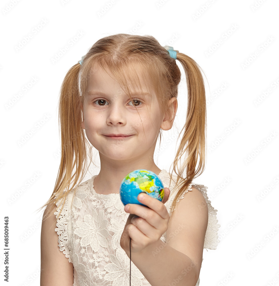 Blonde baby 6 years old, in a white dress shows a globe Blonde baby 6 years old, in a white dress shows a globe