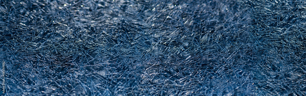 Panoramic ice background with thousands of triangular crystals. Deep blue frozen water surface of a river in Sauerland. Geometric irregular structures in contasting shades of marine. Macro close up Panoramic ice background with thousands of triangular crystals. Deep blue frozen water surface of a river in Sauerland. Geometric irregular structures in contasting shades of marine. Macro close up