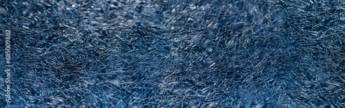 Panoramic ice background with thousands of triangular crystals. Deep blue frozen water surface of a river in Sauerland. Geometric irregular structures in contasting shades of marine. Macro close up photo